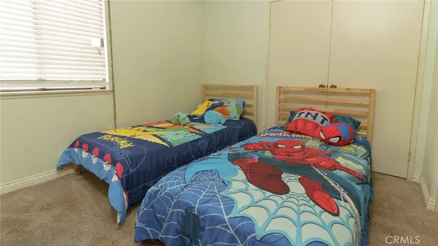 a bedroom with two beds and a painting on the wall