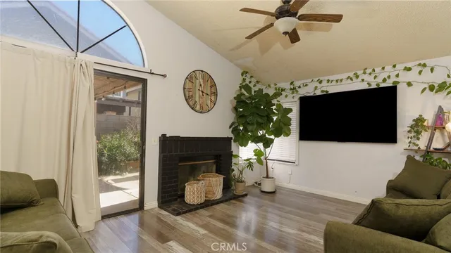 a living room with furniture a flat screen tv and a fireplace
