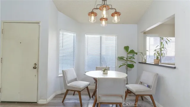 a dining room with wooden floor and chandelier