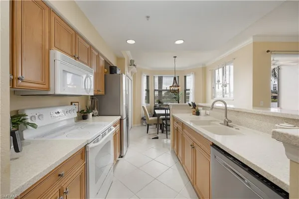 a kitchen with stainless steel appliances kitchen island granite countertop a refrigerator and cabinets