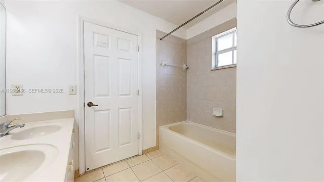 a bathroom with a tub a sink and a shower