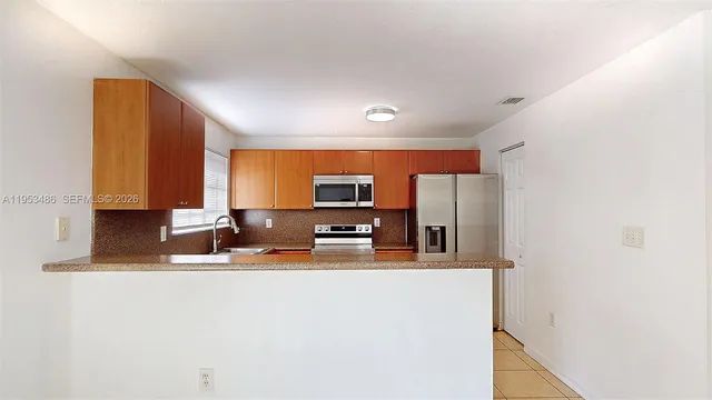 a kitchen with stainless steel appliances granite countertop a sink and a refrigerator