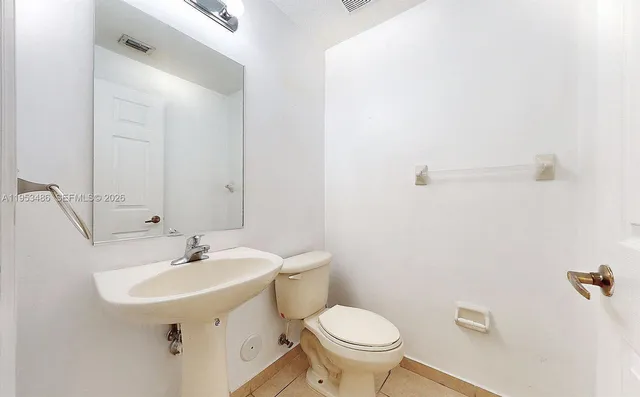 a bathroom with a sink toilet and a mirror