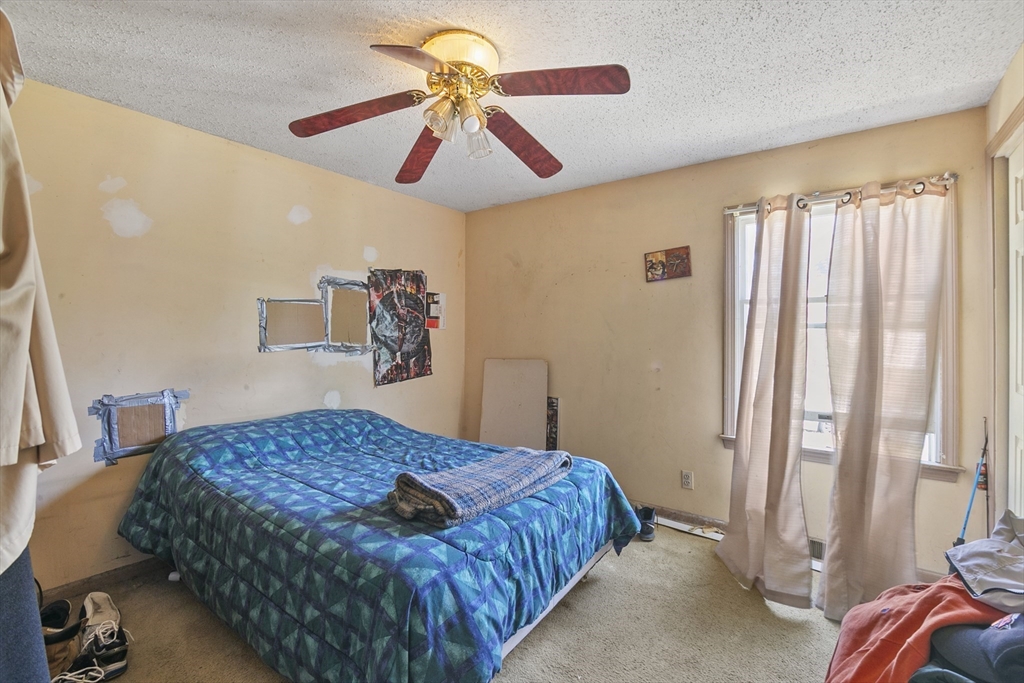 110 Tilton Street Springfield, MA 01109 - Photo 13 of 23 a bedroom with a bed and a chandelier