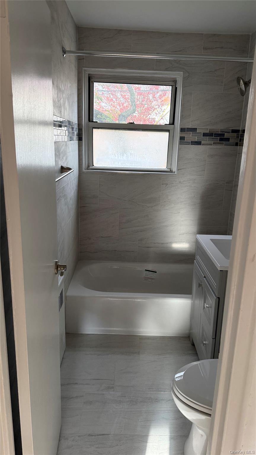 1003 Rottkamp Street, Unit 1 Valley Stream, NY 11580 - Photo 7 of 12 a bathroom with a toilet and a bathtub