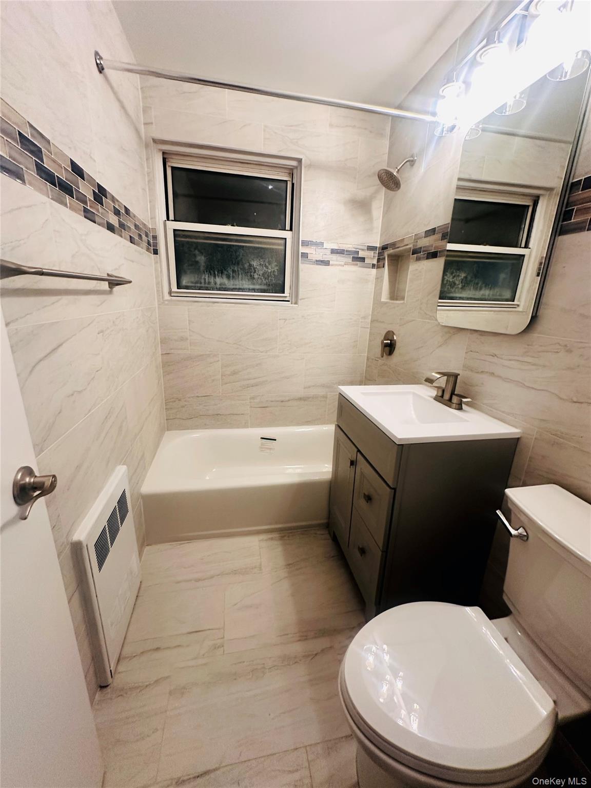 1003 Rottkamp Street, Unit 1 Valley Stream, NY 11580 - Photo 10 of 12 a bathroom with a toilet a sink and bathtub