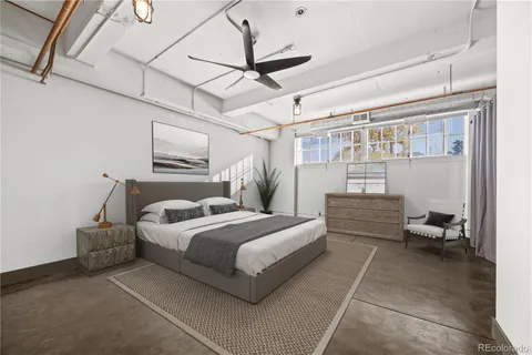 a bedroom with a bed couch and a window