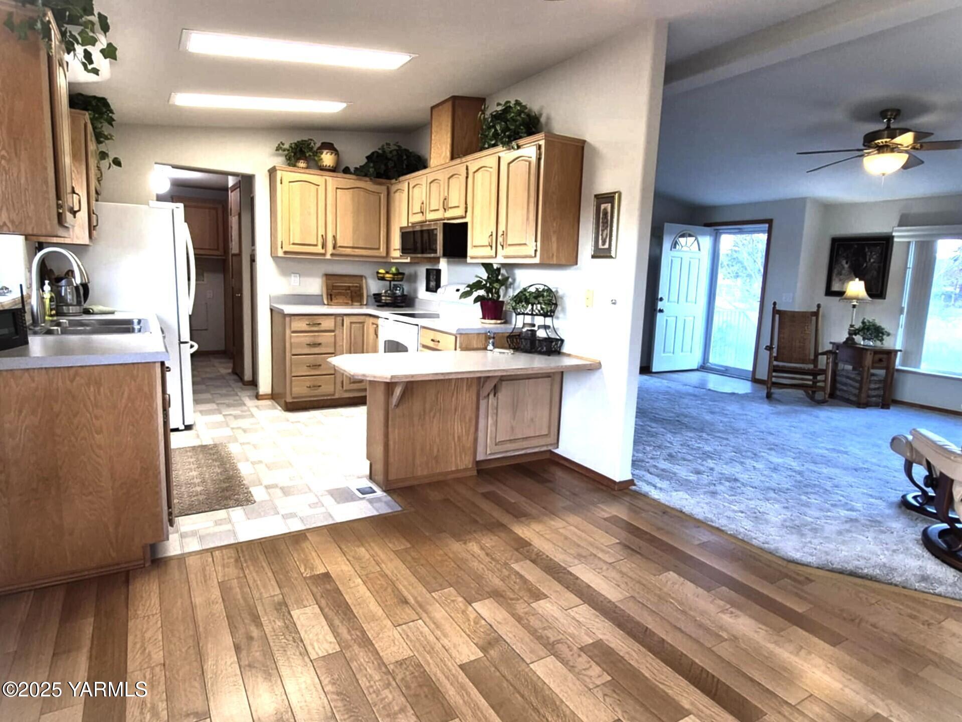 2490 Thompson Road Cowiche, WA 98923 - Photo 48 of 62 a kitchen with stainless steel appliances kitchen island granite countertop a refrigerator oven a sink dishwasher and wooden cabinets with wooden floor