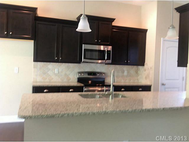 78026 Rillstone Drive, Unit 186 Lancaster, SC 29720 - Photo 7 of 13 a kitchen with granite countertop a stove and a microwave