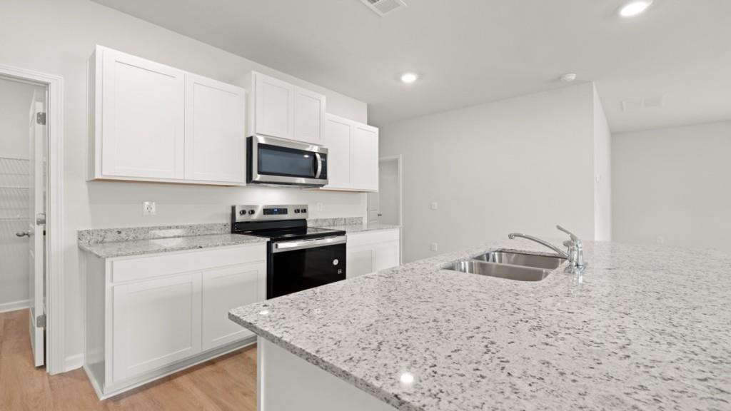 101 Hill Side Road Dallas, GA 30157 - Photo 6 of 31 a kitchen with granite countertop a sink stove and microwave