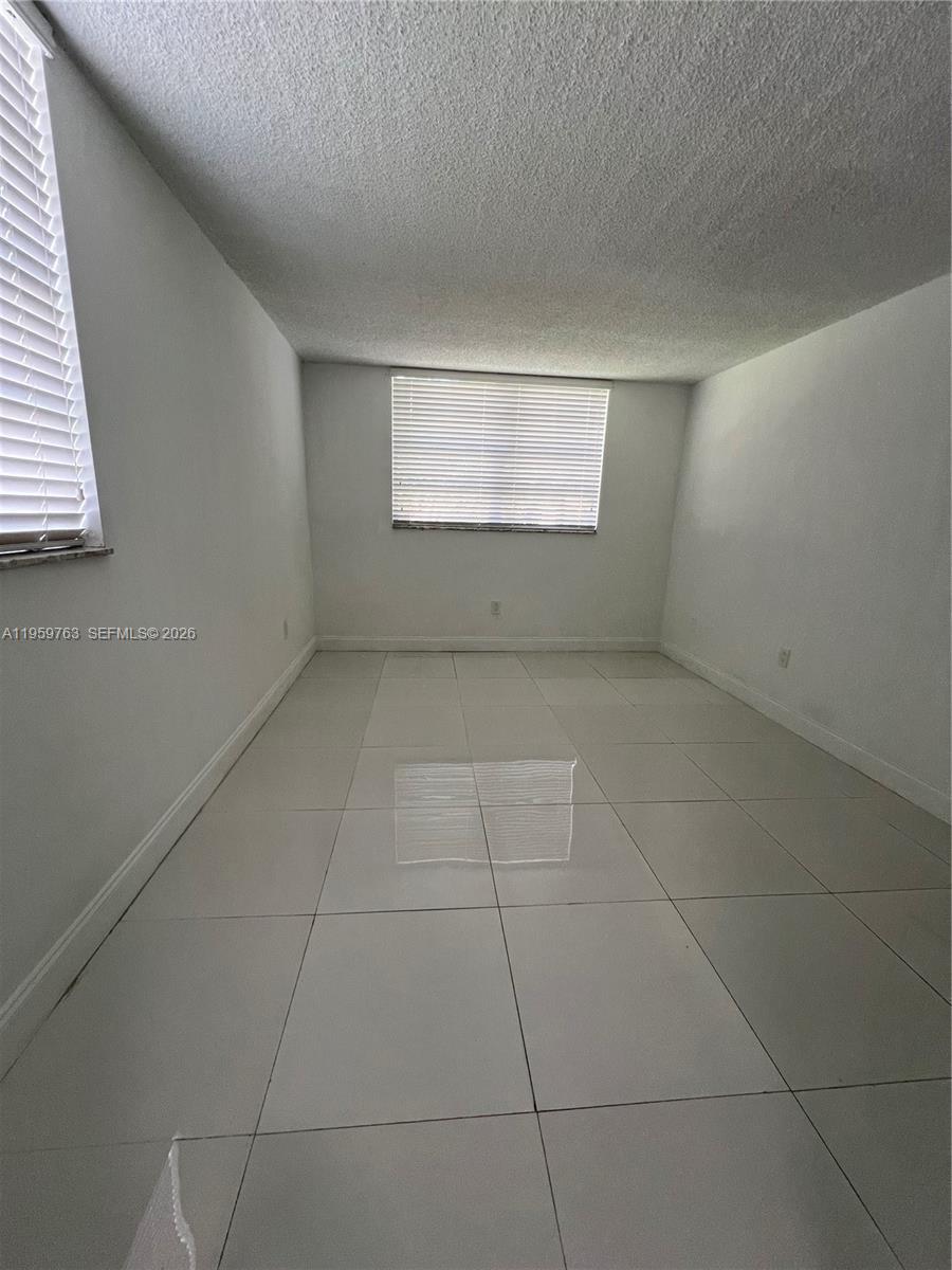 14155 Southwest 87th Street, Unit E201 Miami, FL 33183 - Photo 13 of 14 an empty room with windows
