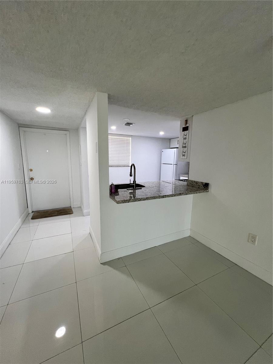 14155 Southwest 87th Street, Unit E201 Miami, FL 33183 - Photo 2 of 14 a kitchen with stainless steel appliances a sink and cabinets
