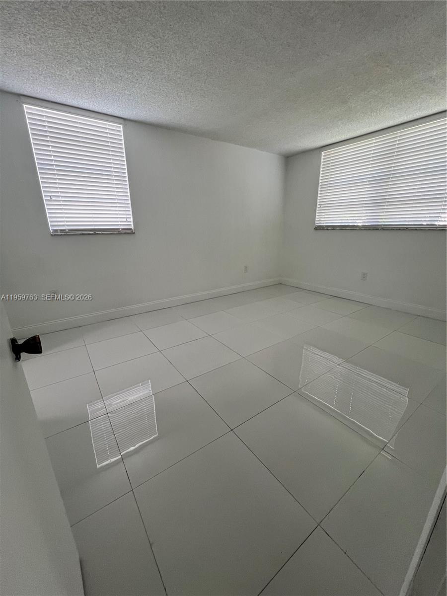 14155 Southwest 87th Street, Unit E201 Miami, FL 33183 - Photo 6 of 14 a view of an empty room with a window