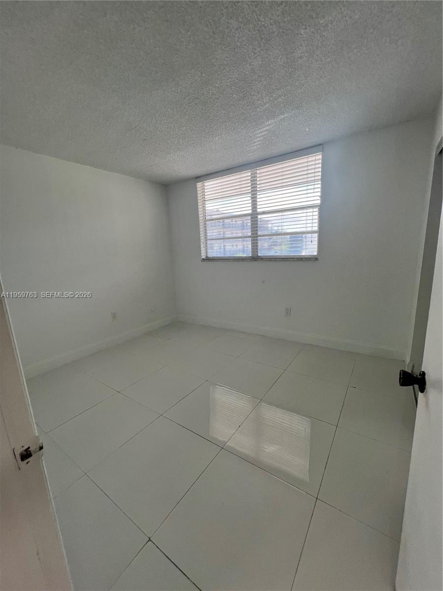 14155 Southwest 87th Street, Unit E201 Miami, FL 33183 - Photo 7 of 14 a view of an empty room with a window