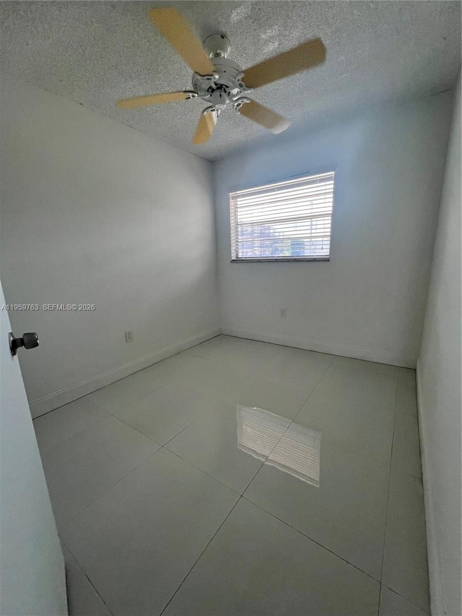 14155 Southwest 87th Street, Unit E201 Miami, FL 33183 - Photo 8 of 14 an empty room with windows and fan