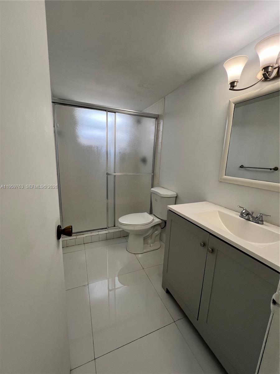 14155 Southwest 87th Street, Unit E201 Miami, FL 33183 - Photo 10 of 14 a bathroom with a sink a toilet and shower