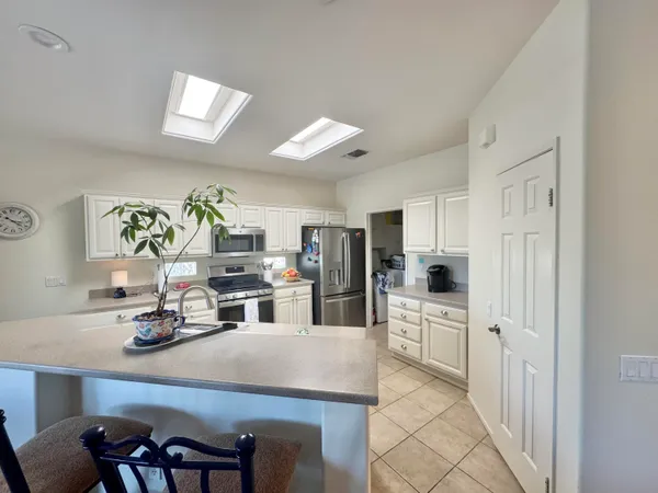 a kitchen with white cabinets and appliances