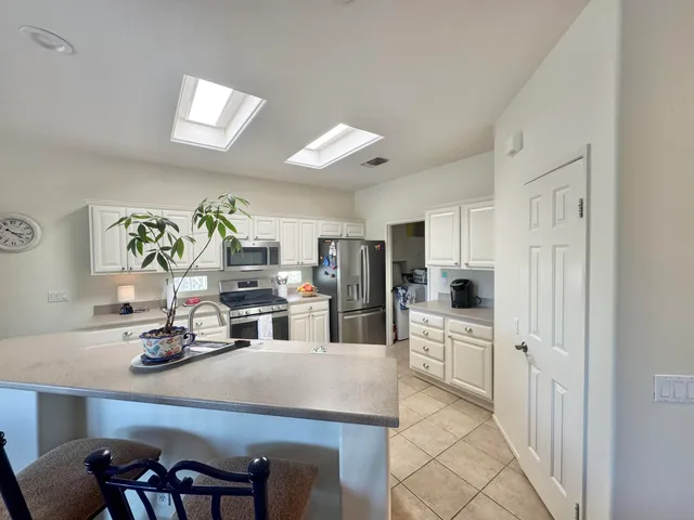 a kitchen with white cabinets and appliances