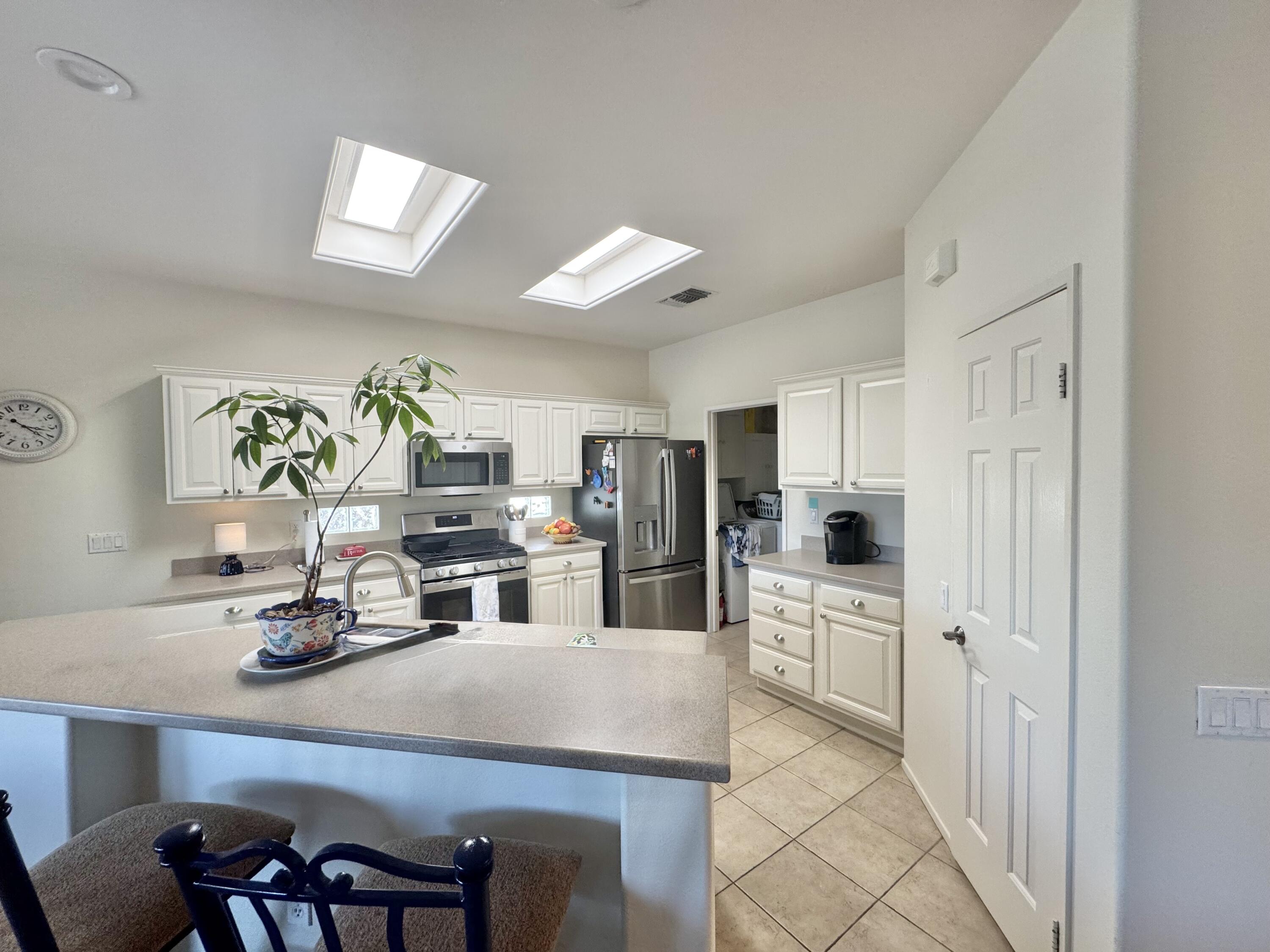 78322 Vinewood Drive Palm Desert, CA 92211 - Photo 13 of 30 a kitchen with white cabinets and appliances