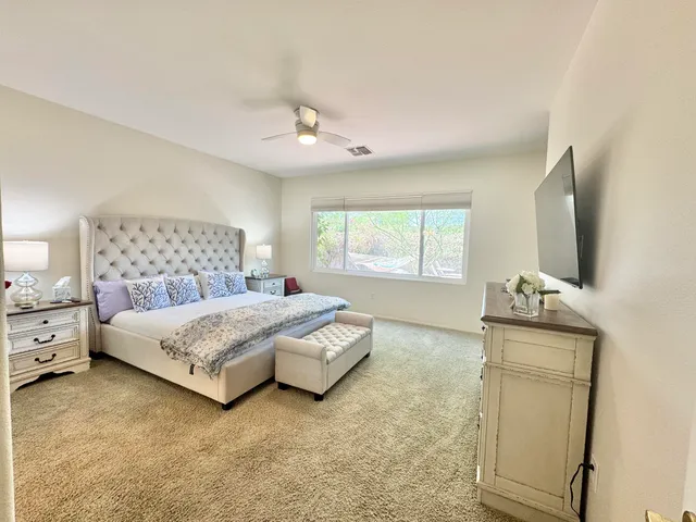 a bedroom with a bed and a flat tv screen on the dresser