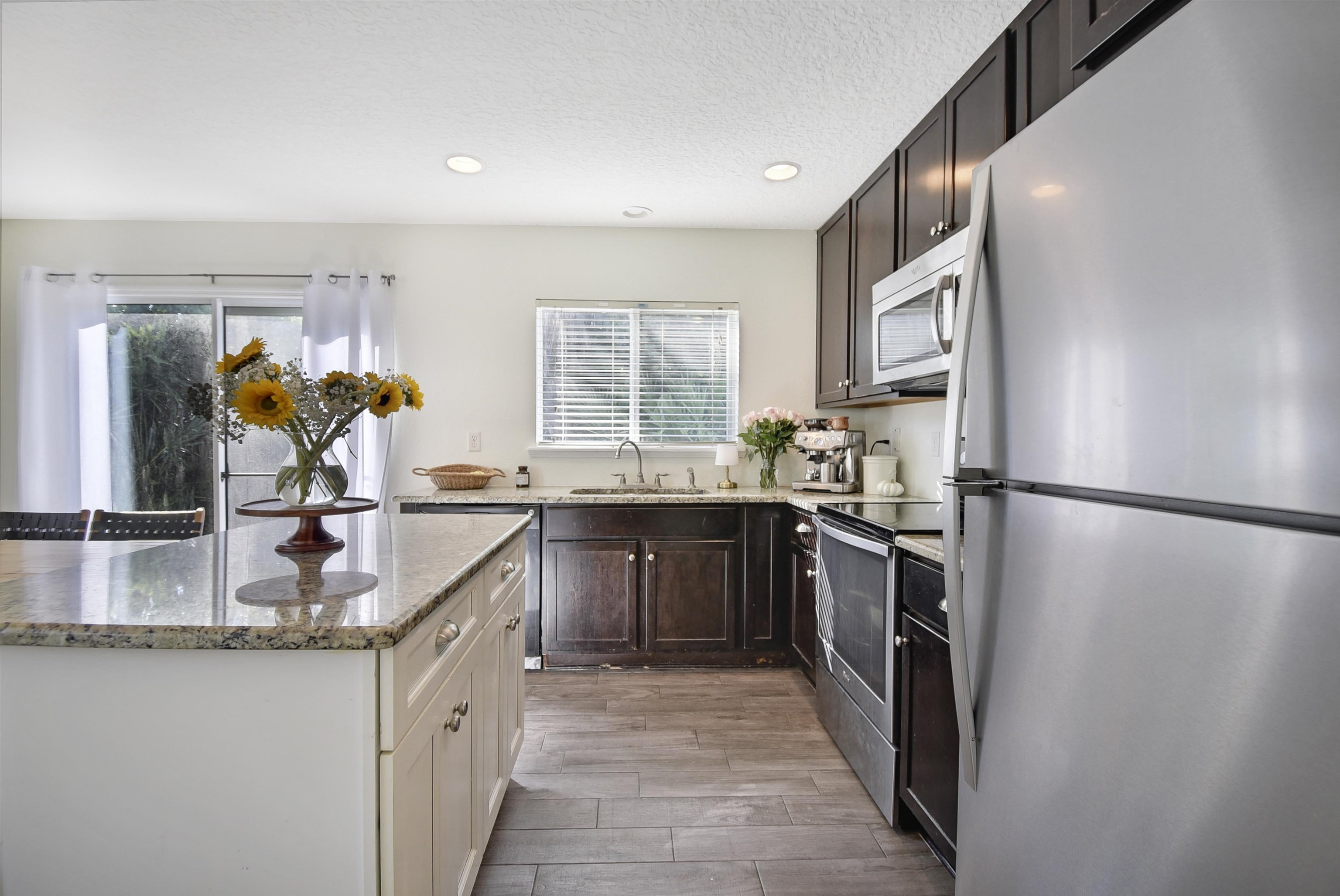 323 Islander Circle St. Augustine, FL 32080 - Photo 12 of 36 a kitchen with stainless steel appliances granite countertop a refrigerator a sink a stove and a wooden floors