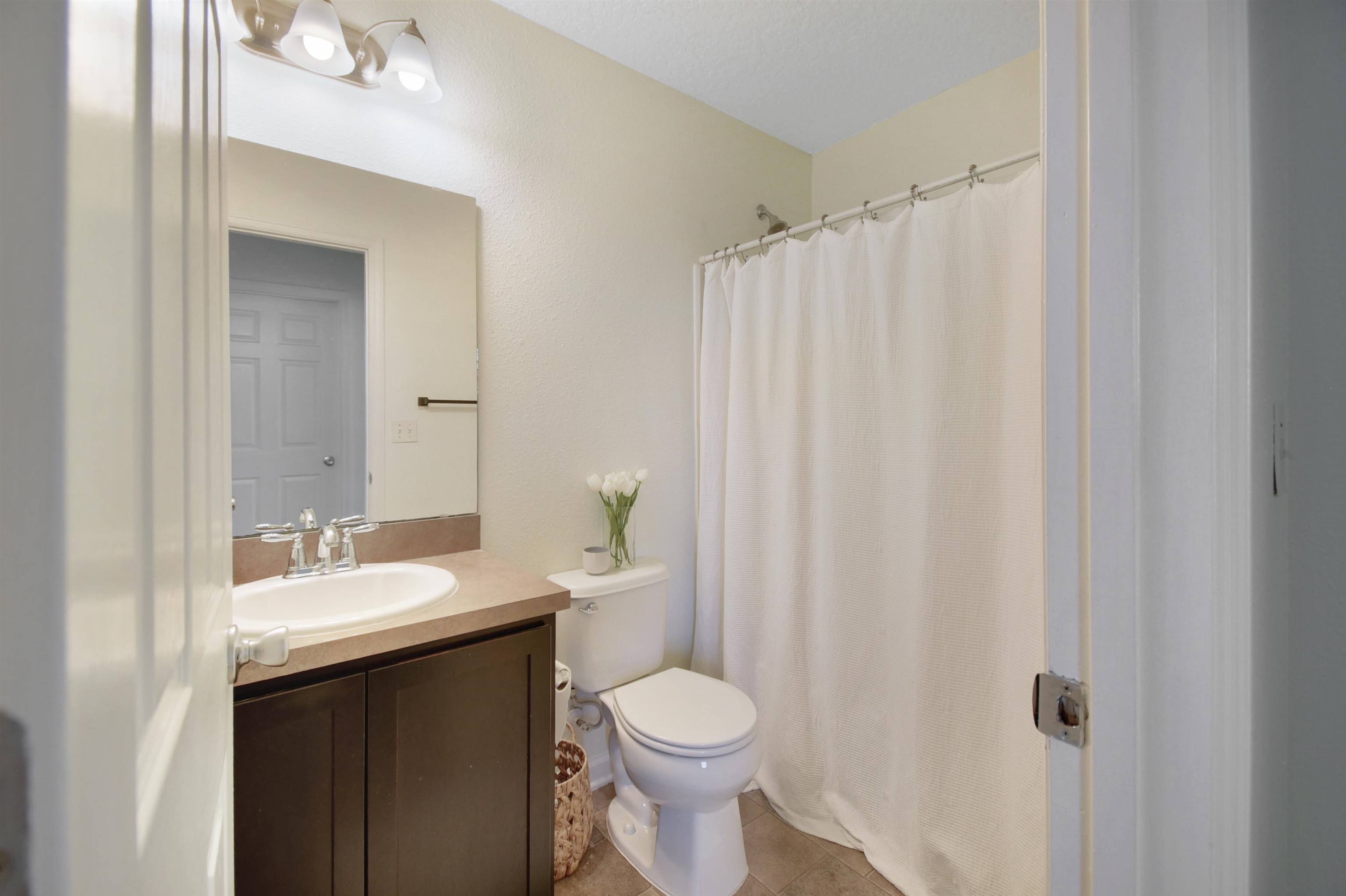 323 Islander Circle St. Augustine, FL 32080 - Photo 26 of 36 a bathroom with a sink a toilet and shower curtain