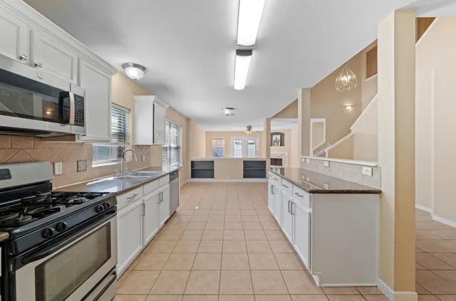 a large kitchen with stainless steel appliances granite countertop a stove and a sink