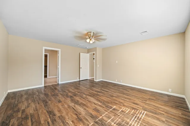 a view of an empty room with wooden floor