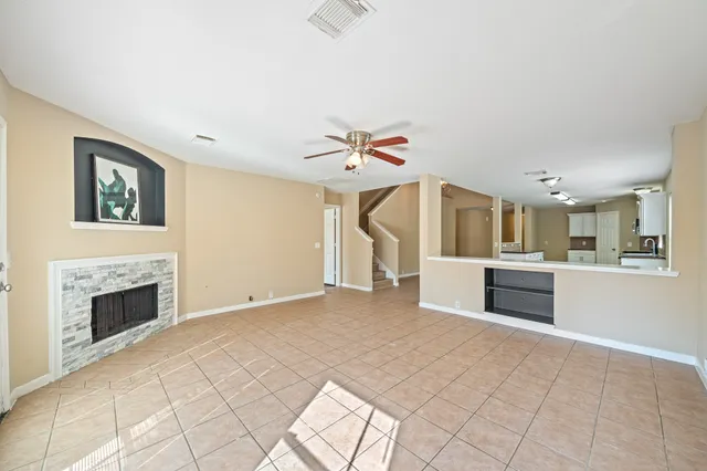 a view of an empty room with a fireplace and a window