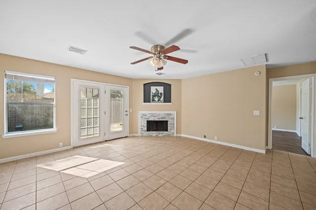 a view of an empty room with a fireplace and a window