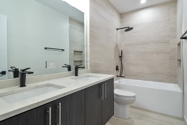 a bathroom with a sink a toilet and shower