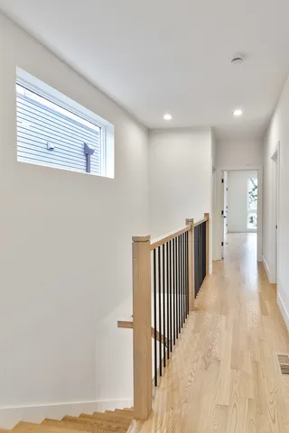 a view of a hallway with wooden floor