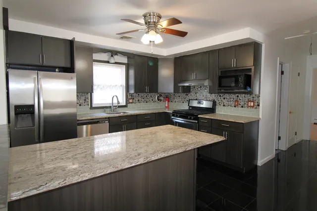 a kitchen with kitchen island a sink stove and refrigerator