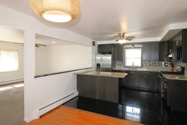 a kitchen with a refrigerator a sink dishwasher and a stove with wooden floor