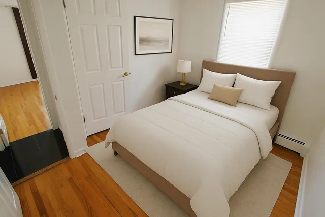 a bedroom with a bed and wooden floor