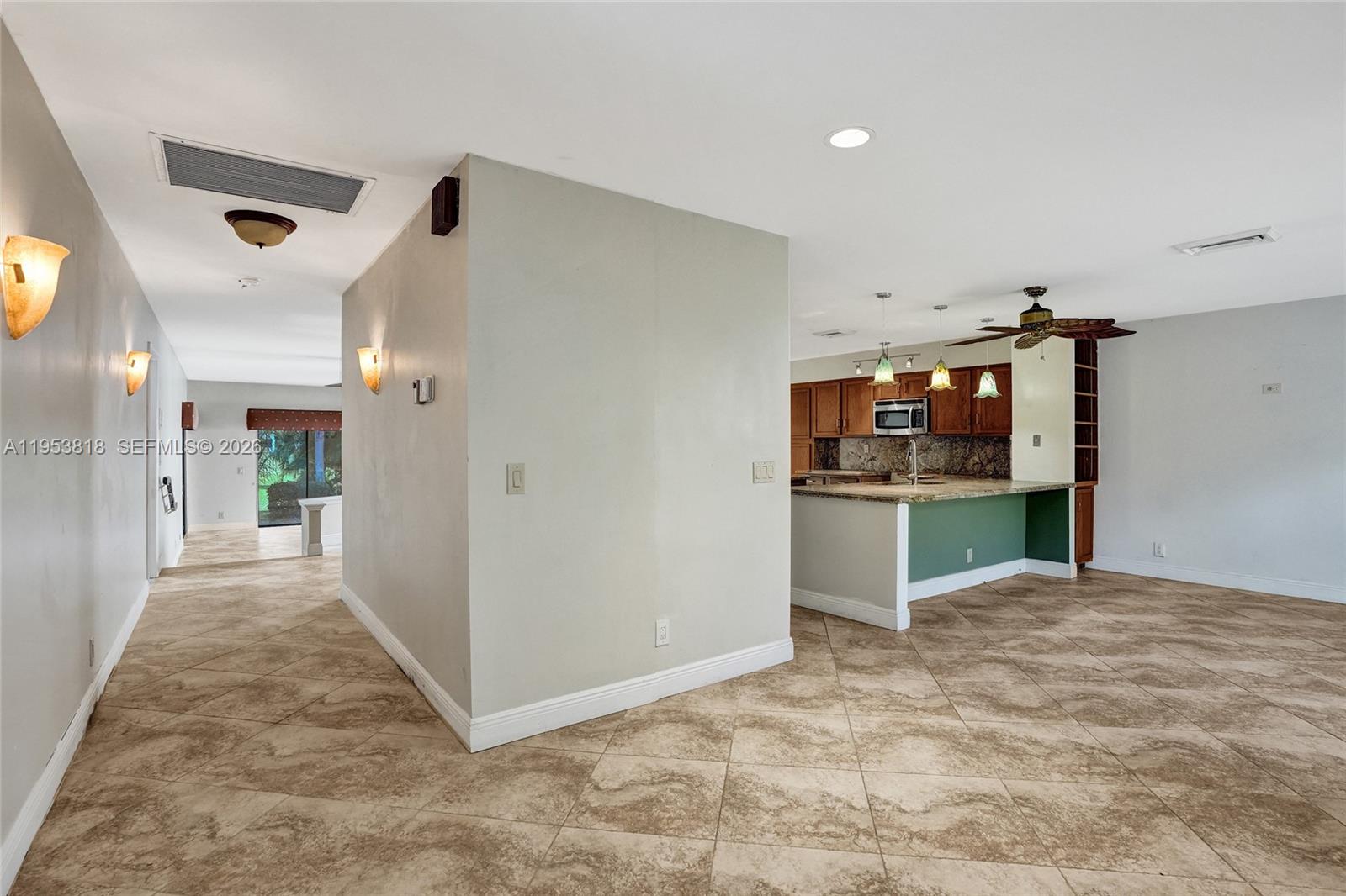 17115 Bay Street Jupiter, FL 33477 - Photo 24 of 73 a view of a hallway with kitchen and cabinets