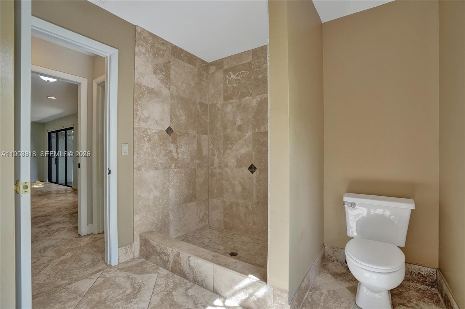 17115 Bay Street Jupiter, FL 33477 - Photo 35 of 73 a bathroom with a granite countertop toilet and a shower