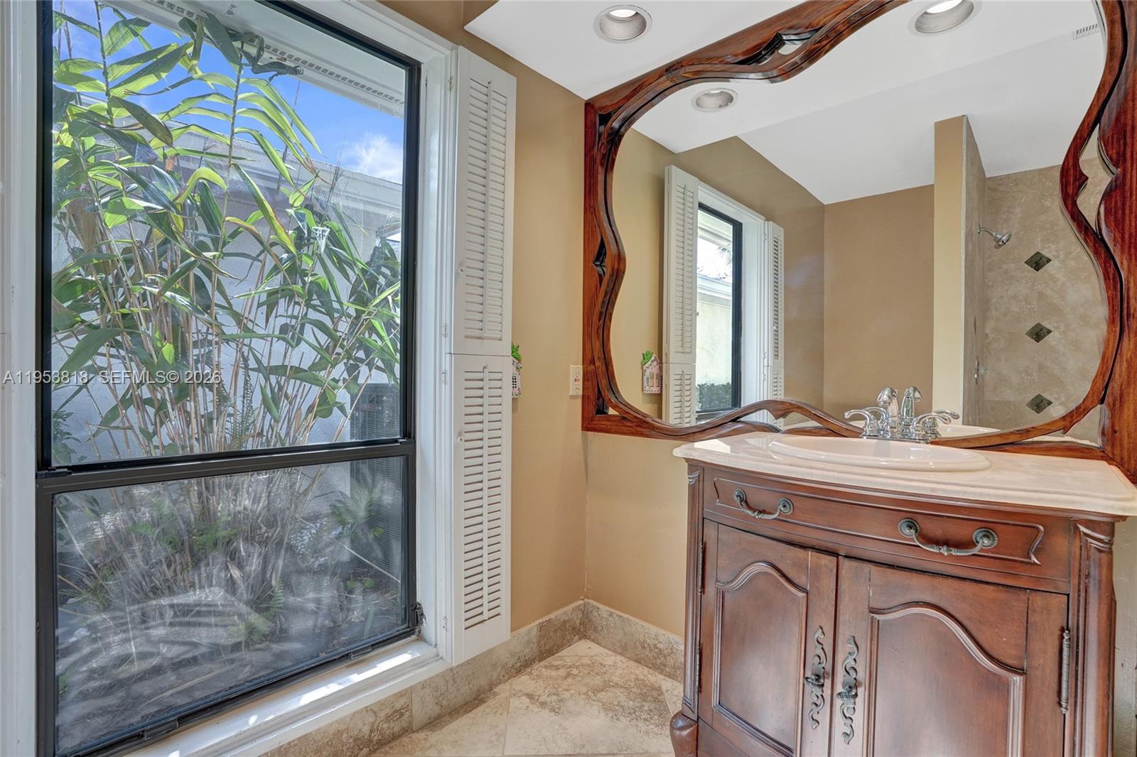 17115 Bay Street Jupiter, FL 33477 - Photo 42 of 73 a bathroom with a granite countertop sink a mirror and shower