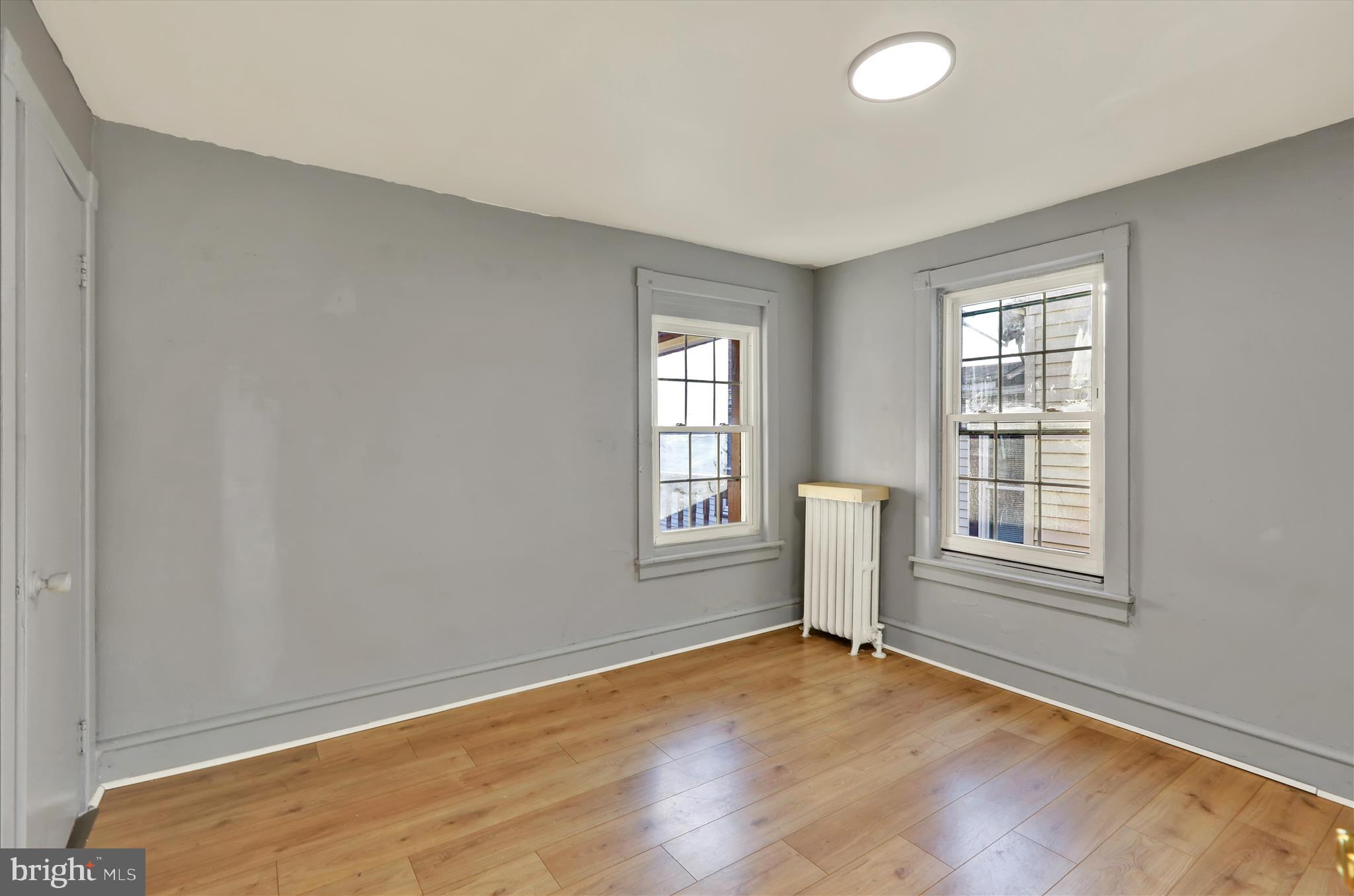 1410 Cotton Street Reading, PA 19602 - Photo 14 of 37 an empty room with wooden floor and windows