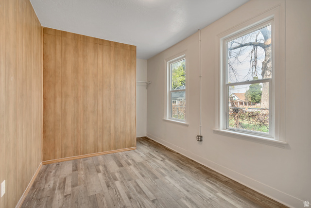 8831 South 400 East Sandy, UT 84070 - Photo 18 of 26 Spare room featuring light wood-type flooring and wooden walls