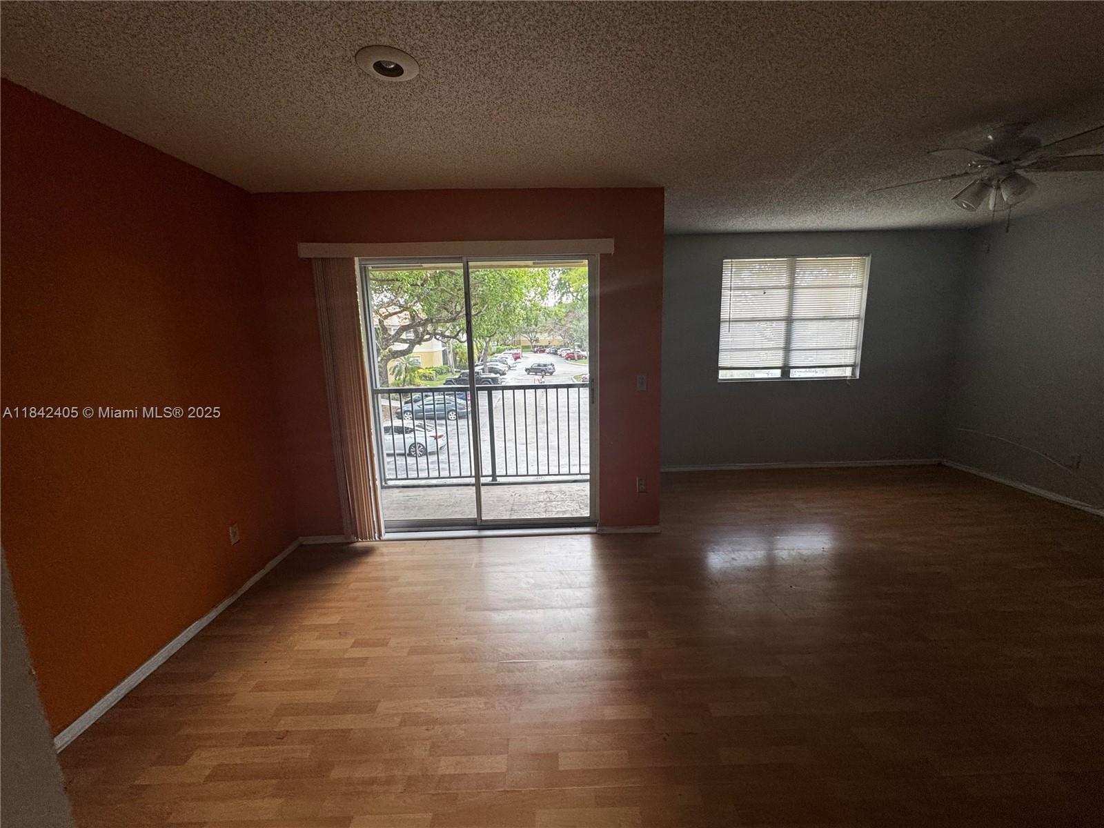 1227 Southwest 46th Avenue, Unit 314 Pompano Beach, FL 33069 - Photo 15 of 36 an empty room with wooden floor and windows with curtains