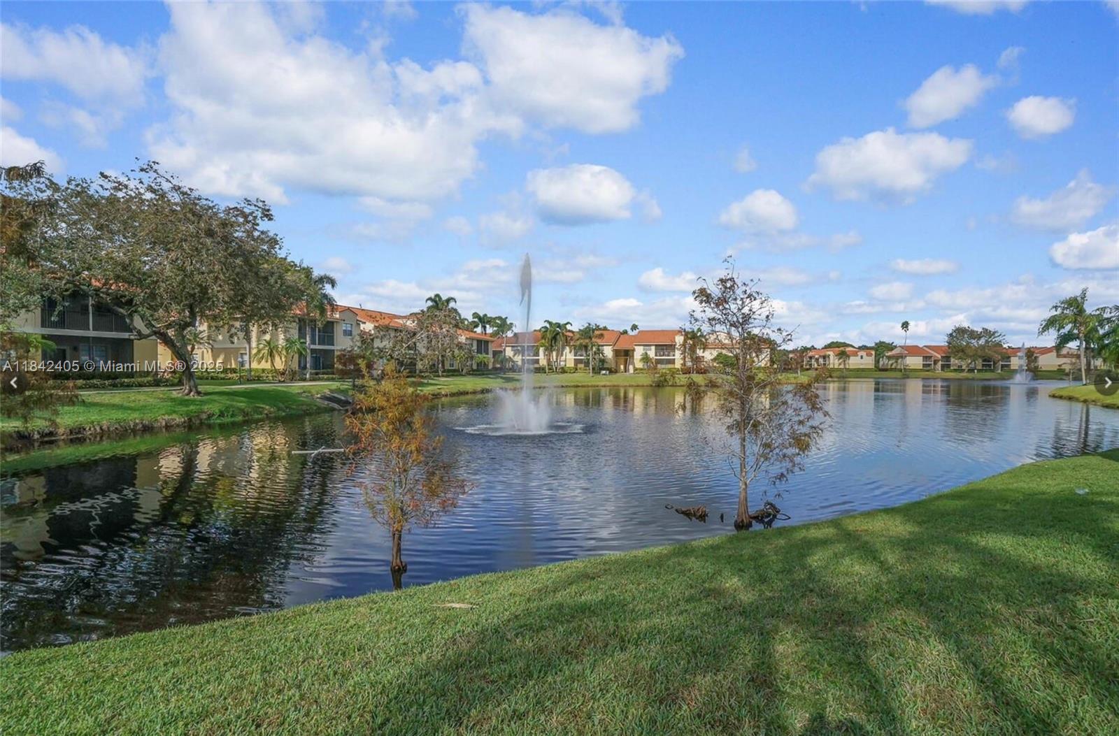 1227 Southwest 46th Avenue, Unit 314 Pompano Beach, FL 33069 - Photo 2 of 36 a lake view with a garden