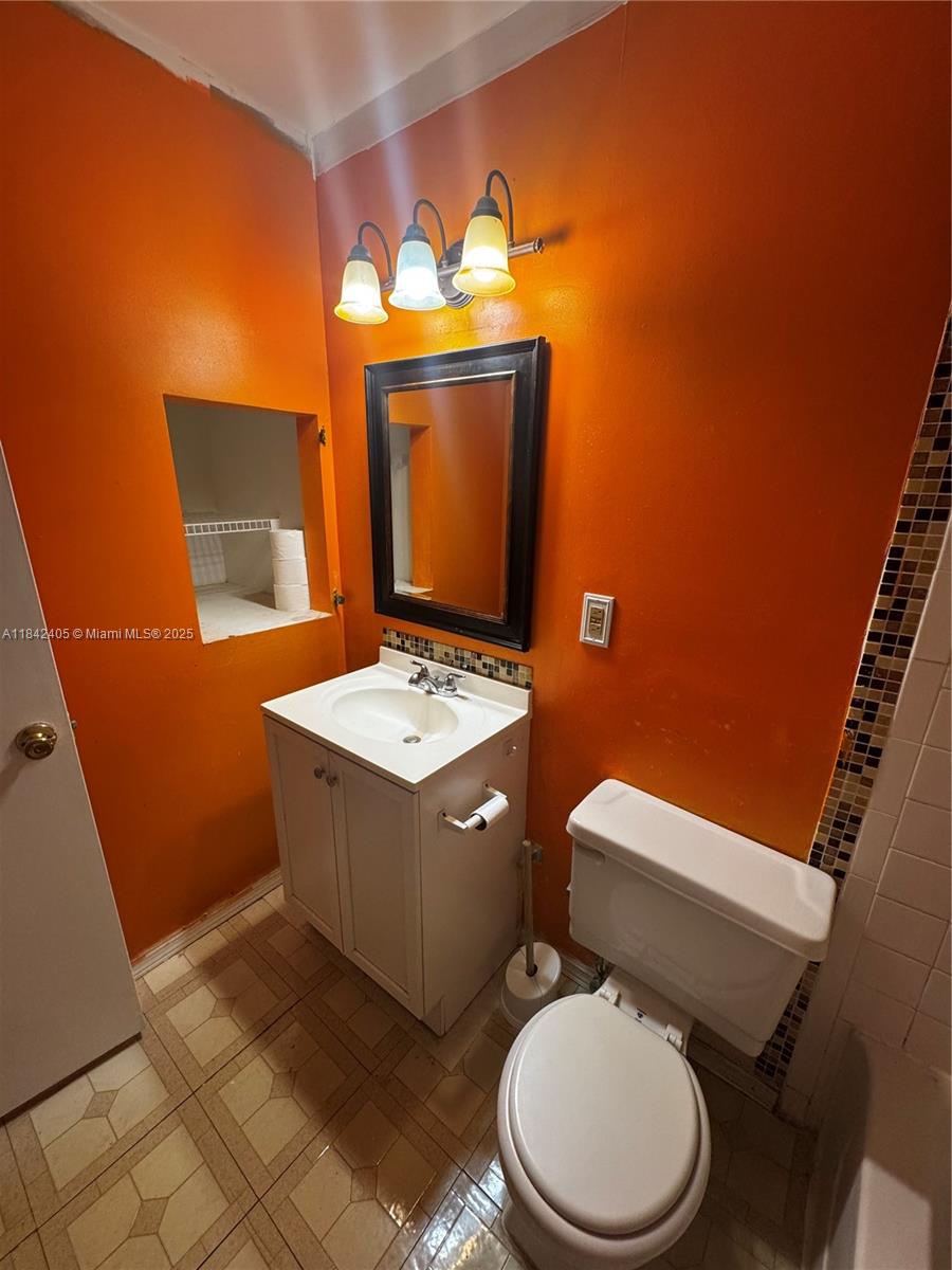 1227 Southwest 46th Avenue, Unit 314 Pompano Beach, FL 33069 - Photo 25 of 36 a bathroom with a toilet sink and mirror