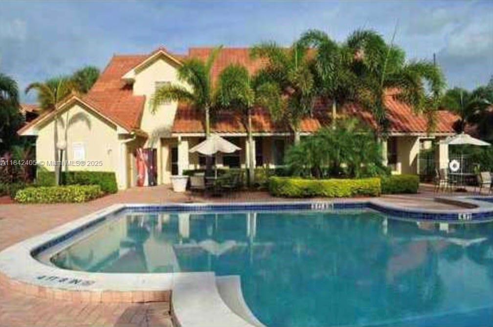 1227 Southwest 46th Avenue, Unit 314 Pompano Beach, FL 33069 - Photo 28 of 36 a view of a swimming pool with a garden