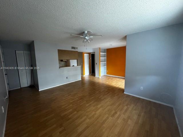 1227 Southwest 46th Avenue, Unit 314 Pompano Beach, FL 33069 - Photo 8 of 36 an empty room with wooden floor and a kitchen