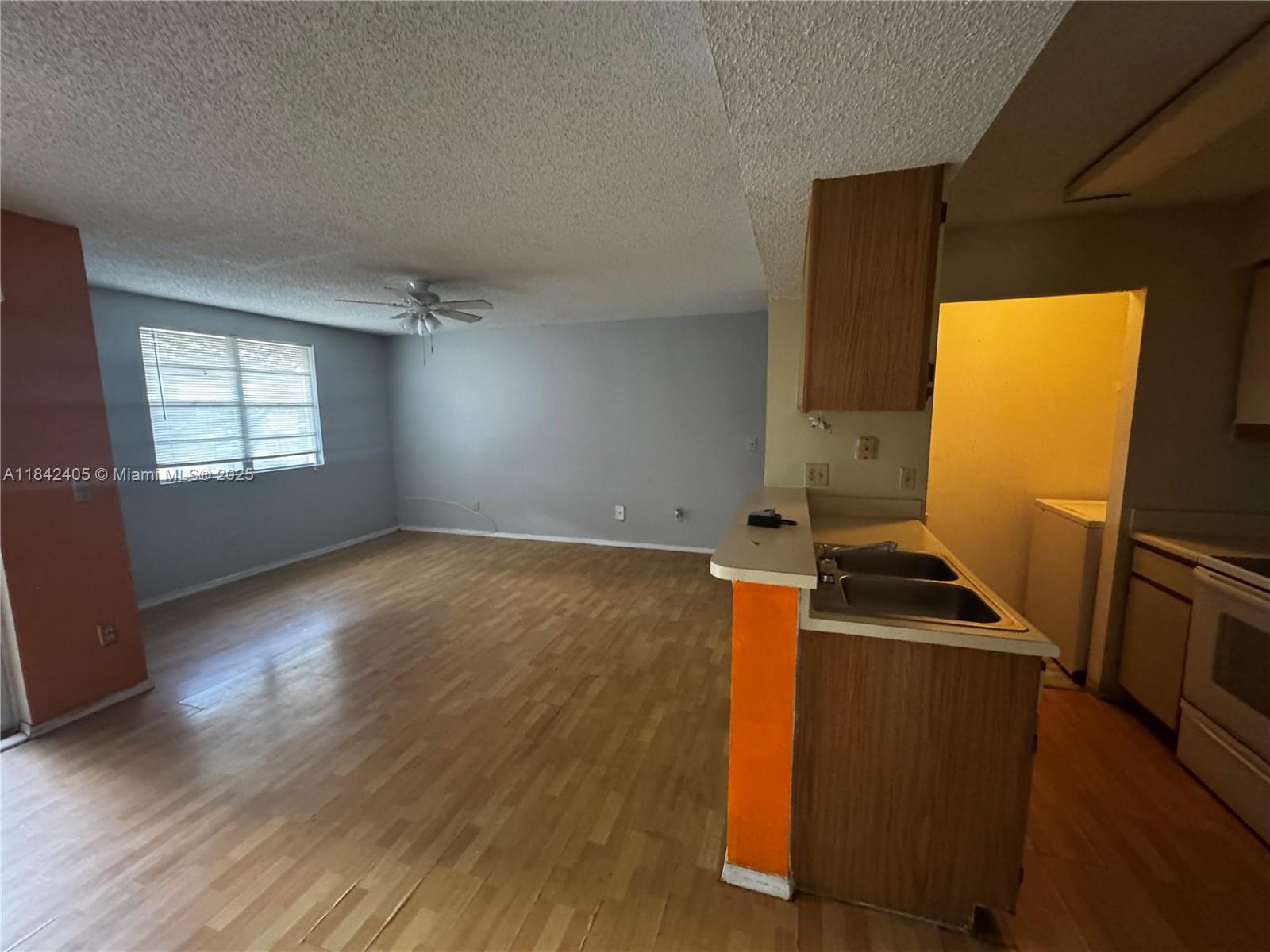 1227 Southwest 46th Avenue, Unit 314 Pompano Beach, FL 33069 - Photo 9 of 36 an empty room with wooden floor and windows