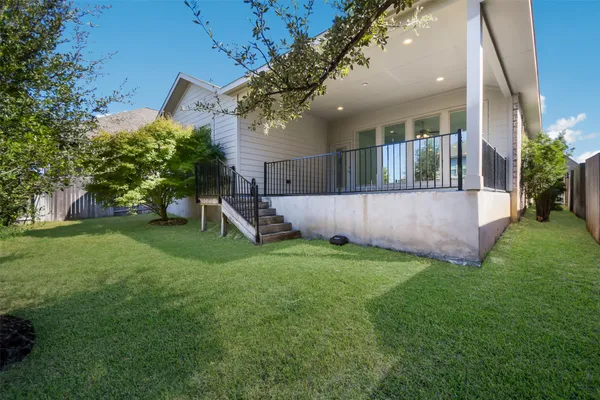 a view of a house with a yard and a large tree