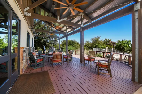a view of a patio with a dining table and chairs with wooden floor and fence
