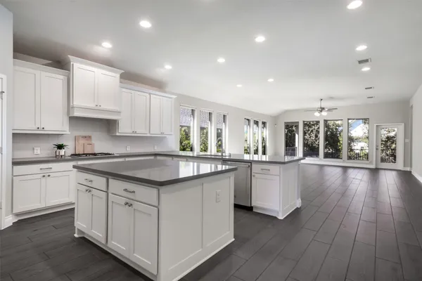 a kitchen with granite countertop white cabinets and wooden floor