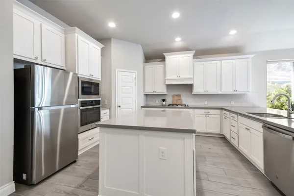 a kitchen with stainless steel appliances cabinets a sink and a refrigerator